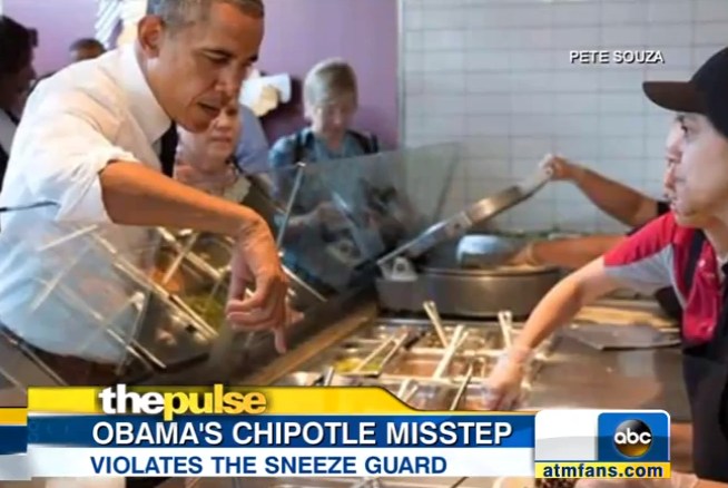 President Obama at a Chipotle counter leaning past the sneeze guard while ordering